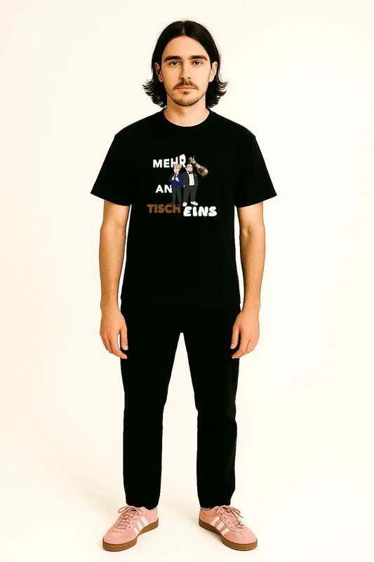 Model trägt schwarzes Papaplatte Fan Shirt mit dem Print „mehr weißwein an tisch eins“
